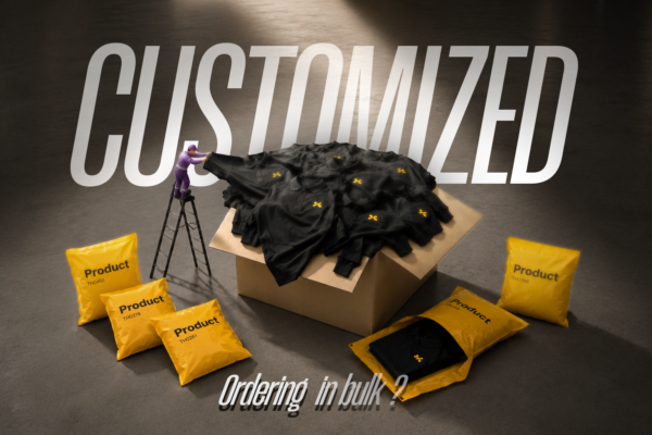 Luxury apparel bulk order packaging scene with black polo shirts in a large cardboard box, surrounded by glossy yellow shipping bags and a miniature worker pulling a shirt from the pile under cinematic studio lighting.