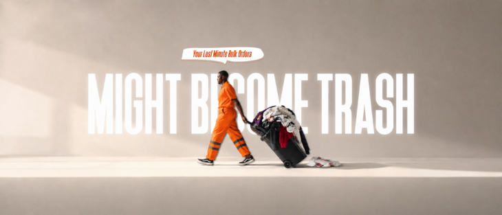 A minimalist editorial image showing a sanitation worker dragging a wheeled bin overflowing with printed t-shirts, symbolizing inventory waste, overproduction, and the hidden business costs of urgent bulk t-shirt orders.